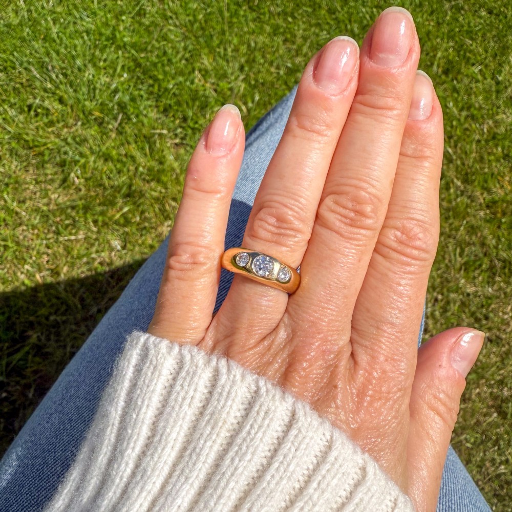 A thick yellow gold ring featuring three flush-set round diamonds embedded across the top band. View VI