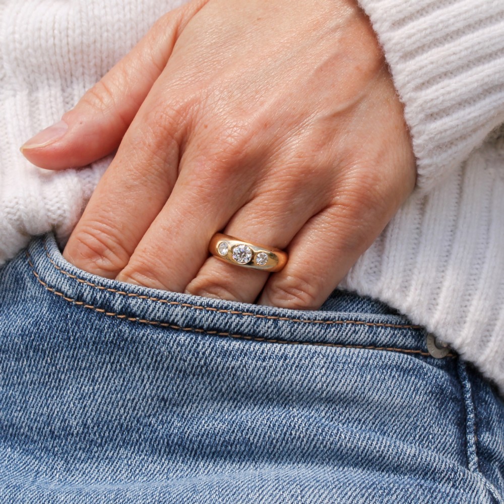 A thick yellow gold ring featuring three flush-set round diamonds embedded across the top band. View VII