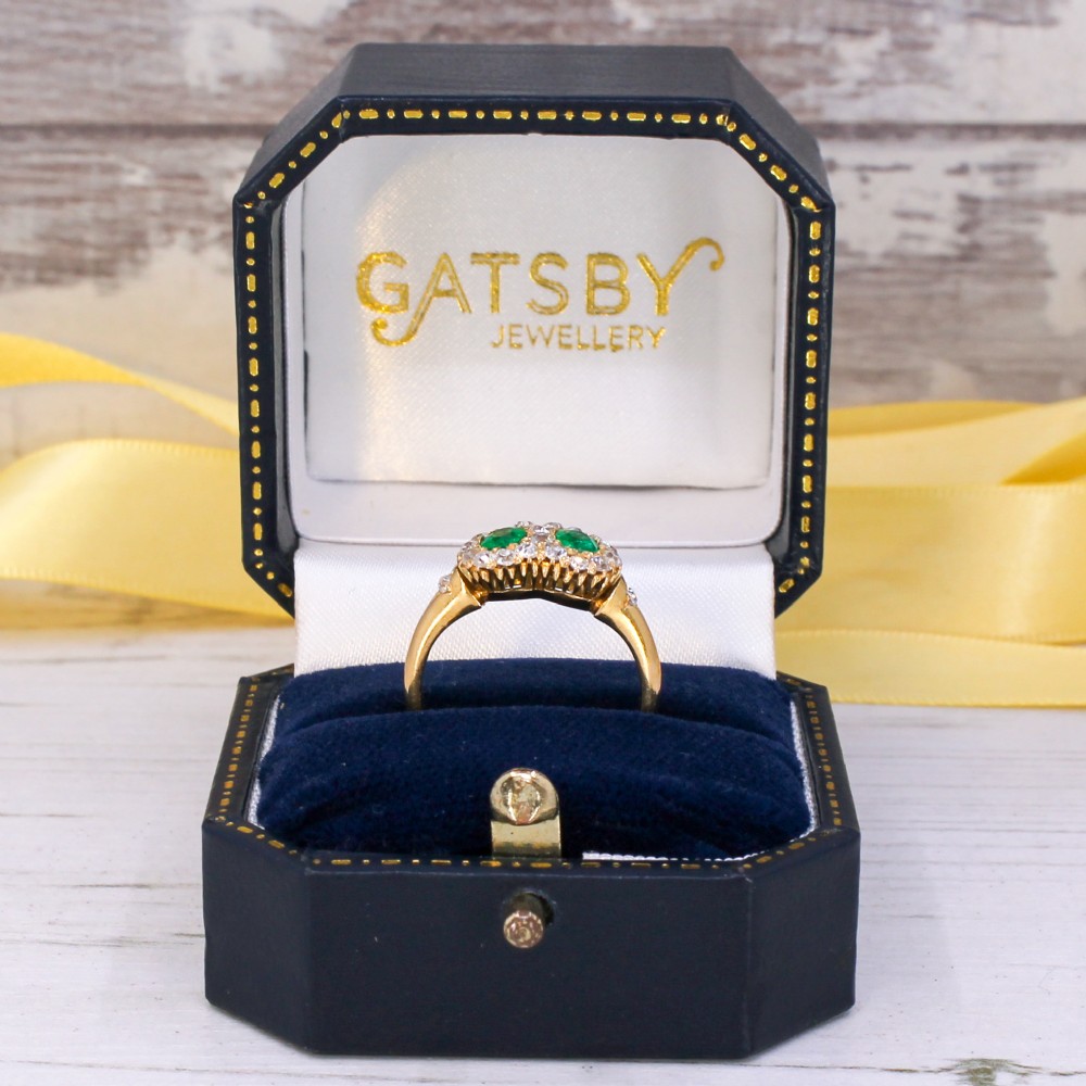 A late Victorian yellow gold double cluster ring set with two bright green oval emeralds, each surrounded by a halo of old-cut diamonds. View IX