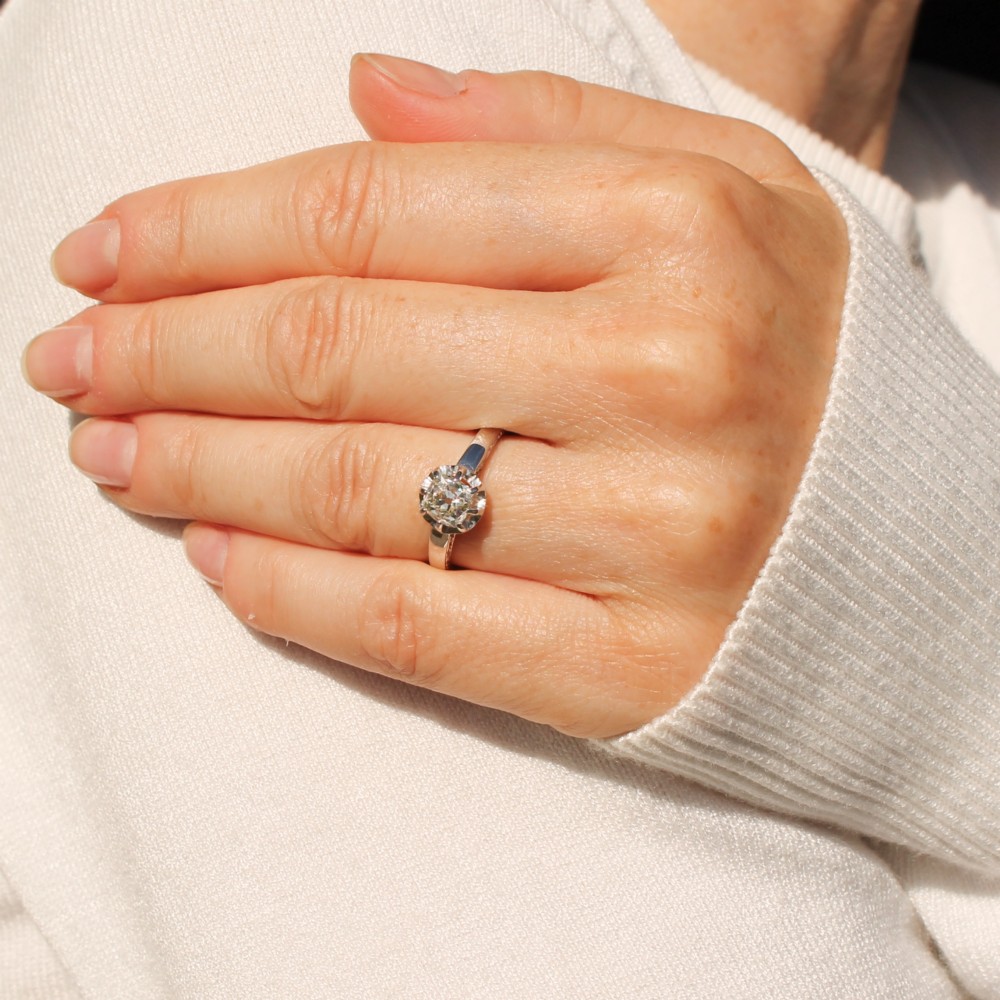 A mid-century white metal solitaire engagement ring featuring a central old cut diamond in a multi-claw raised setting. View II