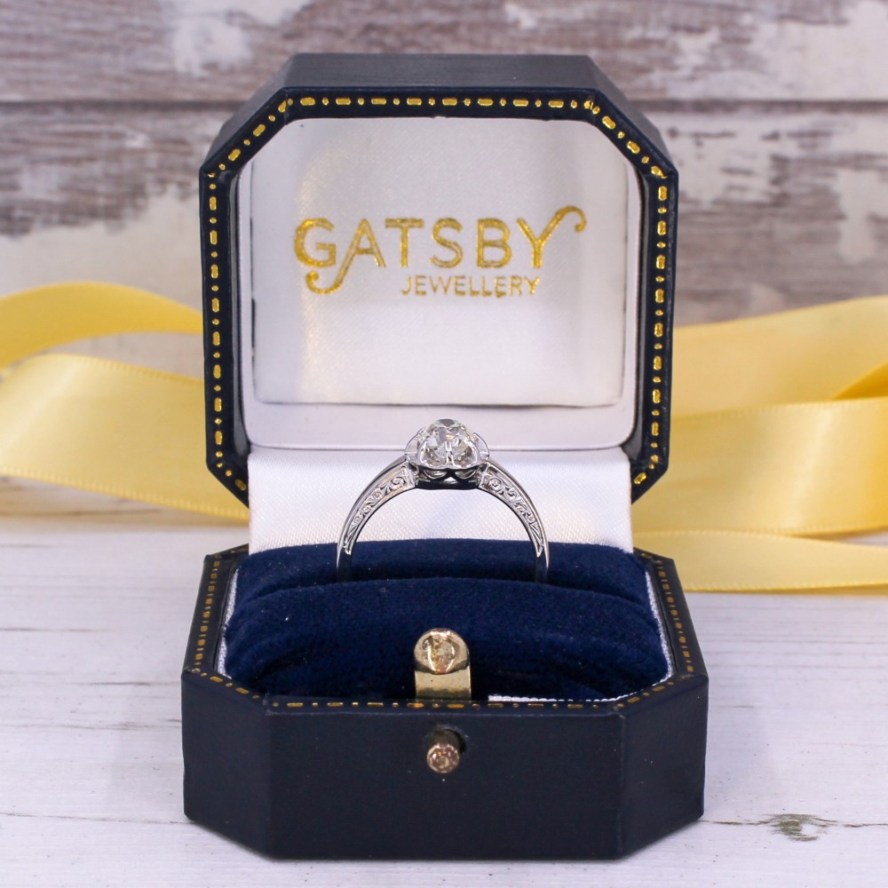 A mid-century white metal solitaire engagement ring featuring a central old cut diamond in a multi-claw raised setting. View IX