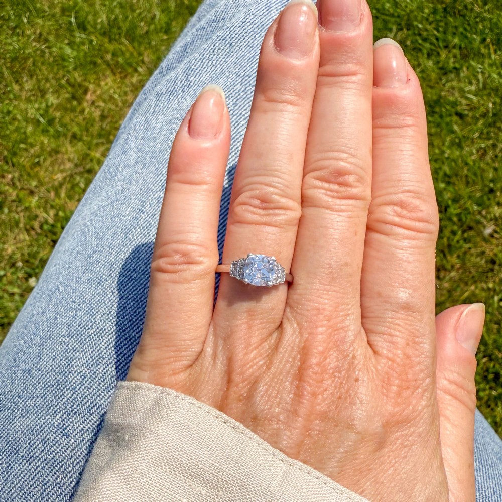 An Art Deco diamond ring featuring a central cushion-shaped old cut diamond mounted in a platinum band with stepped diamond shoulders. View II