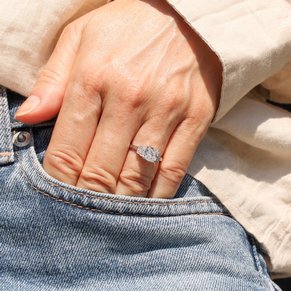 An Art Deco diamond ring featuring a central cushion-shaped old cut diamond mounted in a platinum band with stepped diamond shoulders. View VI