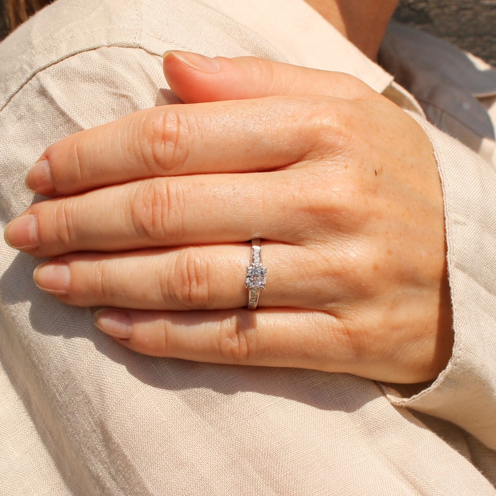 A vintage platinum engagement ring featuring a central old cut diamond flanked by diamond-set shoulders. View VI