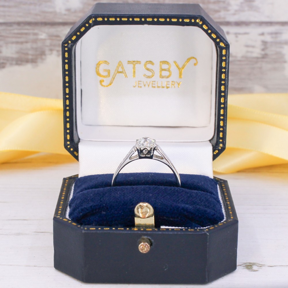 A vintage platinum engagement ring featuring a central old cut diamond flanked by diamond-set shoulders. View IX