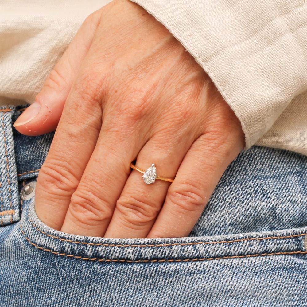 A vintage yellow gold solitaire ring featuring a single pear-cut diamond set within white metal claws. View II