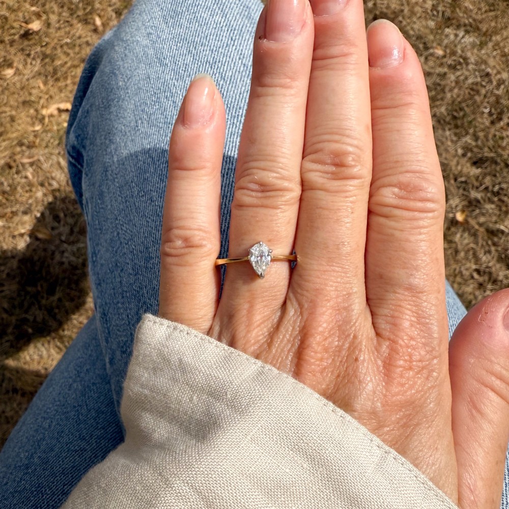 A vintage yellow gold solitaire ring featuring a single pear-cut diamond set within white metal claws. View VI