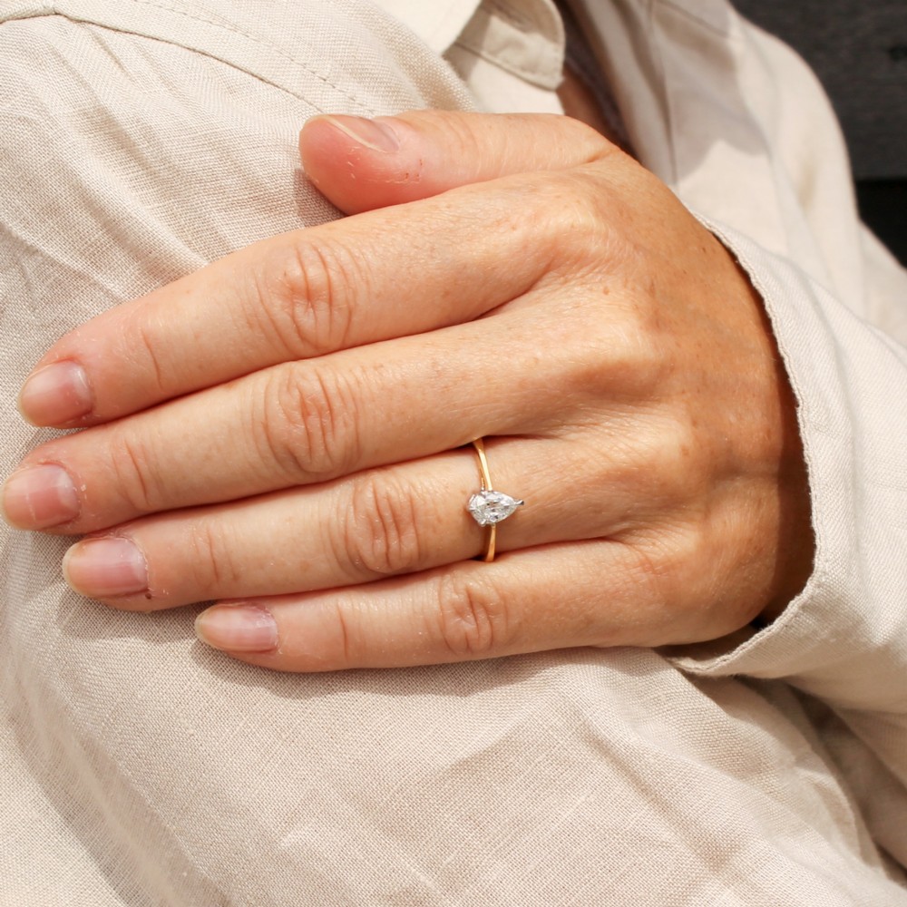A vintage yellow gold solitaire ring featuring a single pear-cut diamond set within white metal claws. View VII