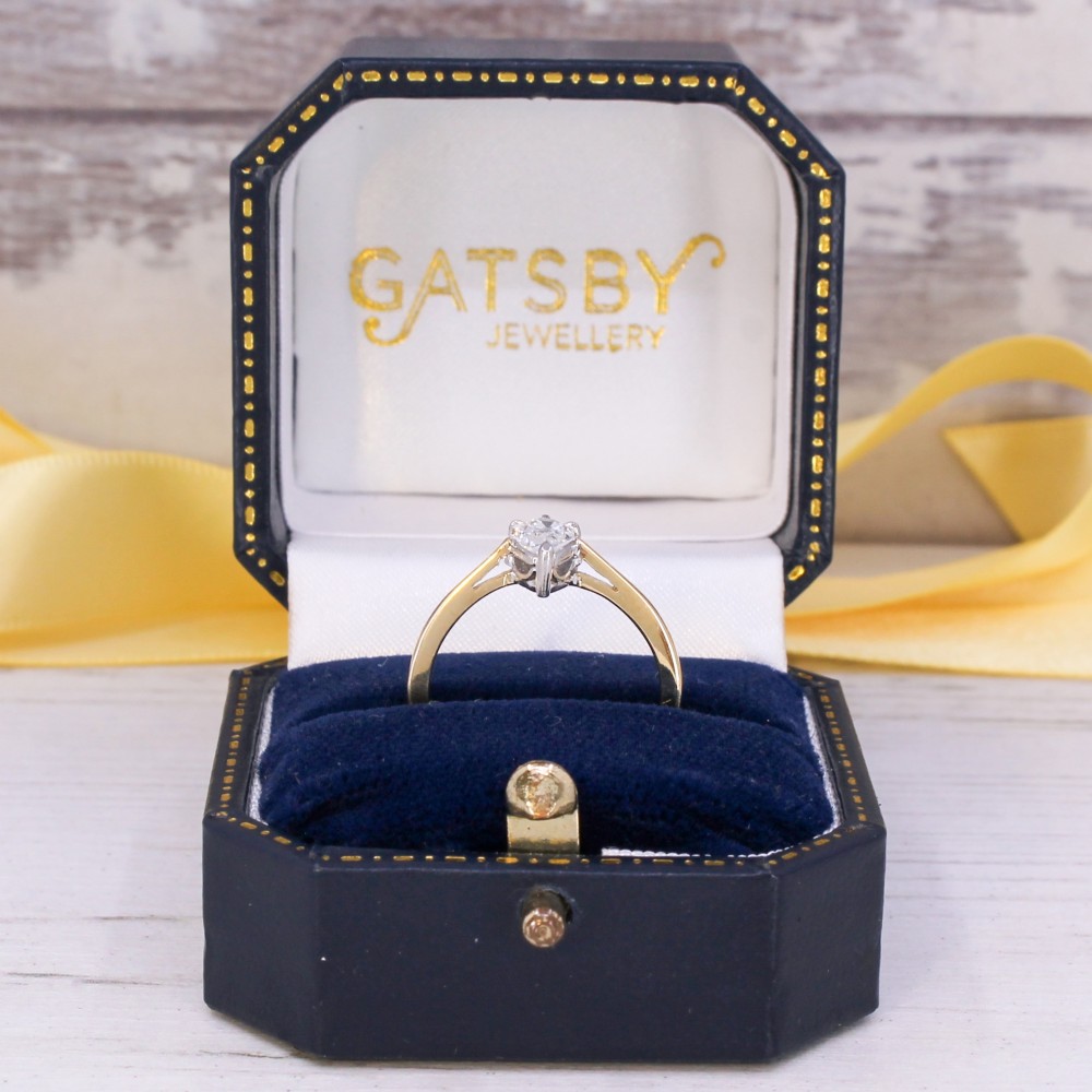 A vintage yellow gold solitaire ring featuring a single pear-cut diamond set within white metal claws. View IX