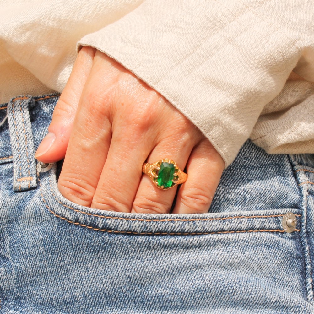 An antique gold ring featuring a cushion-cut green tsavorite garnet held in multi-claw settings with scroll-engraved shoulders. View VI