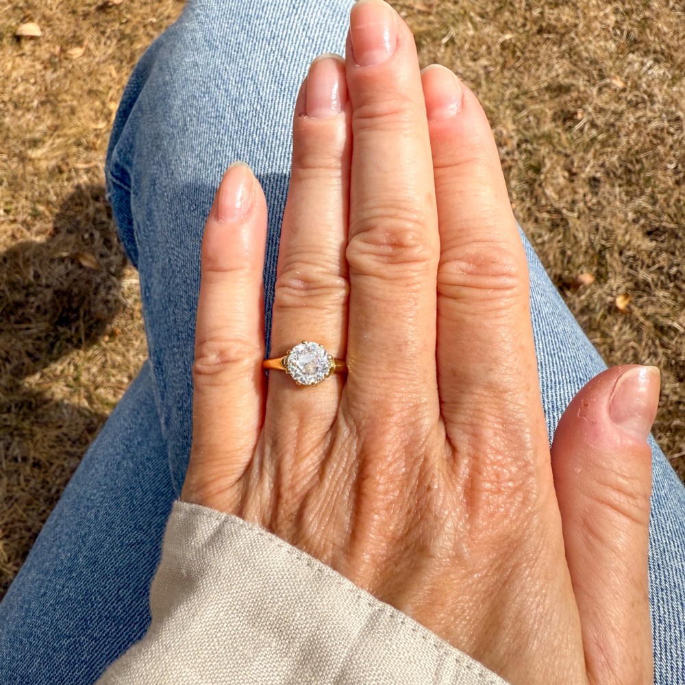 A vintage yellow gold engagement ring featuring a prominent round old cut diamond held in a multi-claw setting. View VII