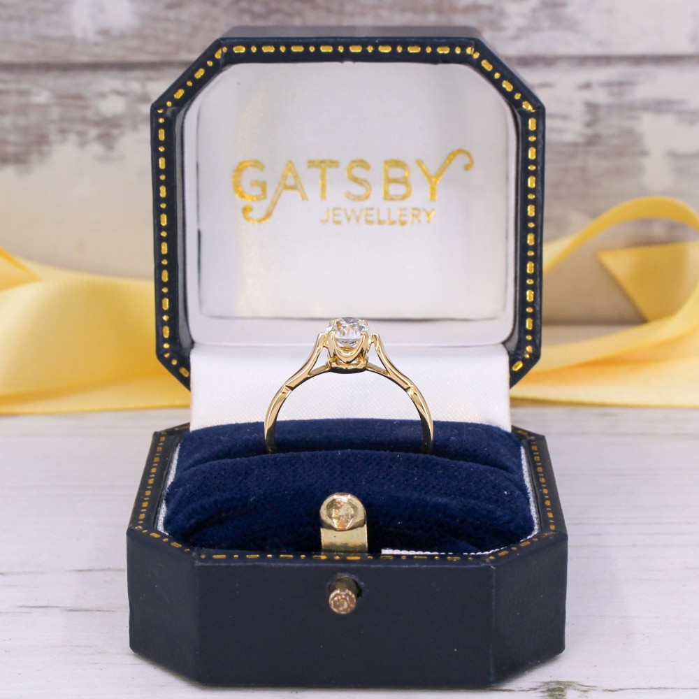 A vintage 1930s yellow gold ring featuring a central claw-set oval cut diamond with tapered shoulders. View IX