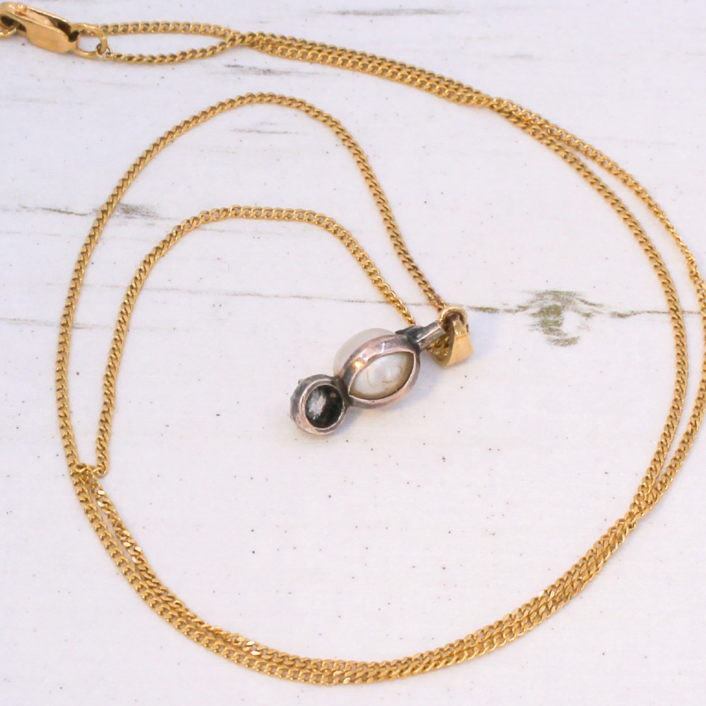 An antique gold chain holding a vertical drop pendant featuring a natural pearl suspended between two bezel-set diamonds. View VI