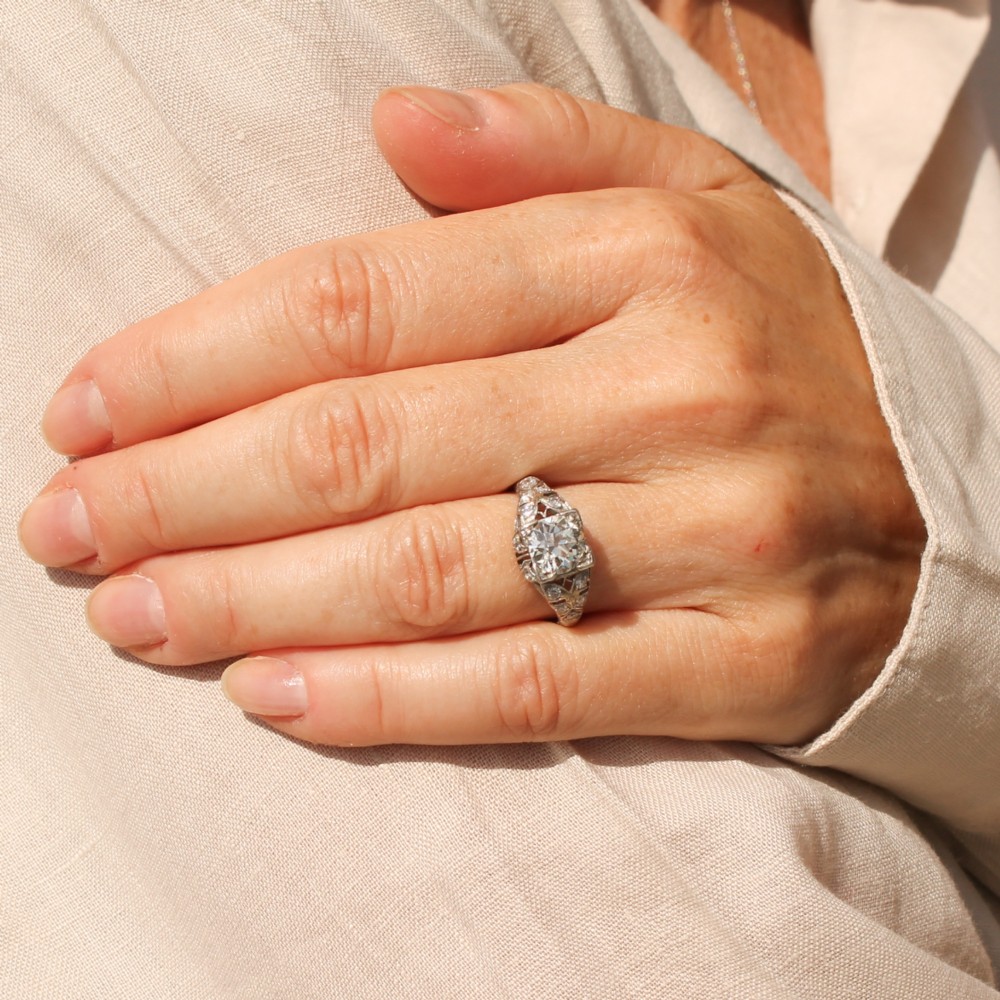 An Art Deco platinum engagement ring featuring a central old European cut diamond set within intricate pierced filigree shoulders. View II