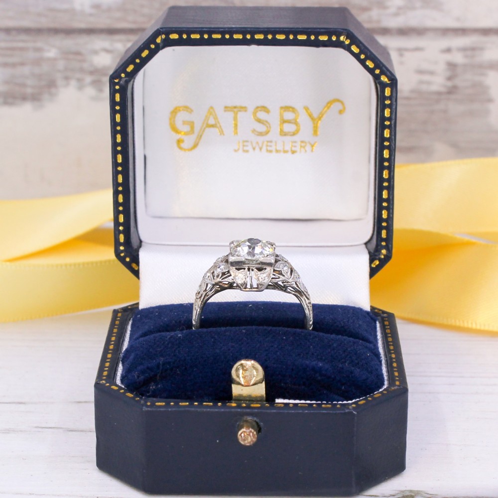 An Art Deco platinum engagement ring featuring a central old European cut diamond set within intricate pierced filigree shoulders. View IX