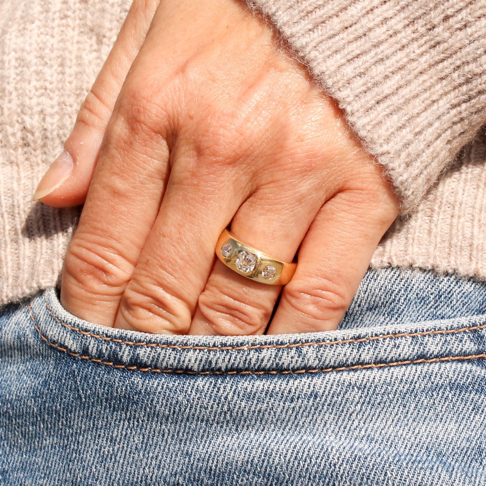 A smooth yellow gold wide band ring featuring three flush-set old cut diamonds across the front. View VII
