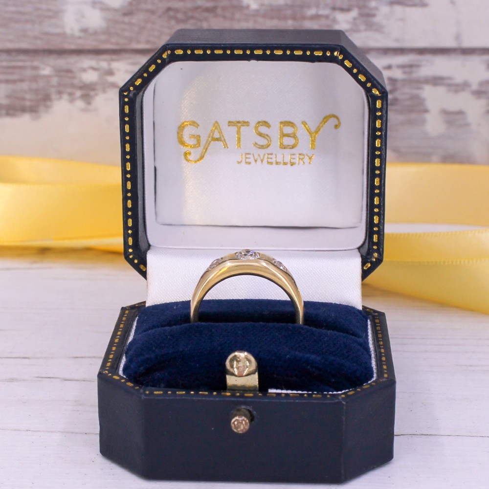 A smooth yellow gold wide band ring featuring three flush-set old cut diamonds across the front. View IX