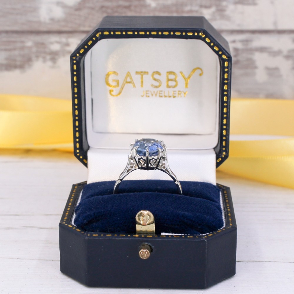 An Art Deco platinum solitaire ring featuring a large oval-cut light blue sapphire held in an eight-claw setting. View VIII