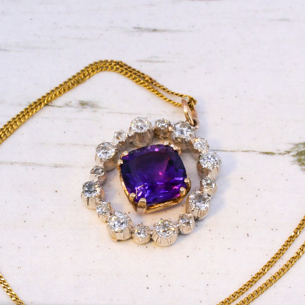 An antique yellow gold pendant featuring a central cushion-cut purple amethyst encircled by an openwork gold border and a halo of old-cut diamonds. View VII