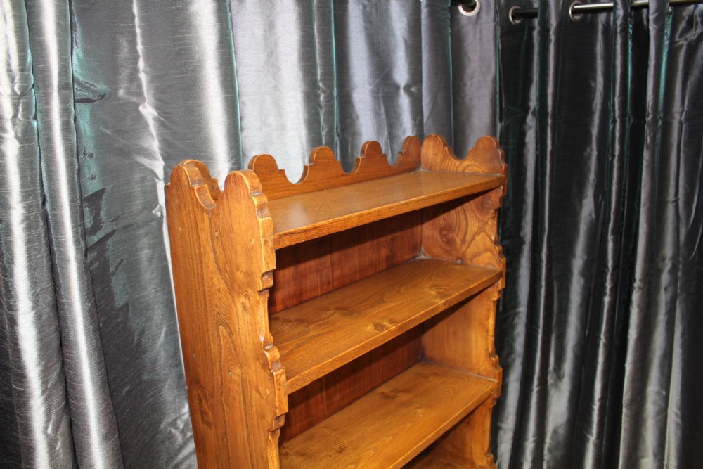 A tall antique elm open bookcase featuring seven shelves with decorative scalloped side profiles. View II