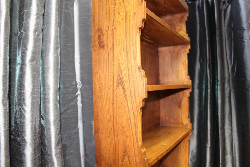A tall antique elm open bookcase featuring seven shelves with decorative scalloped side profiles. View III