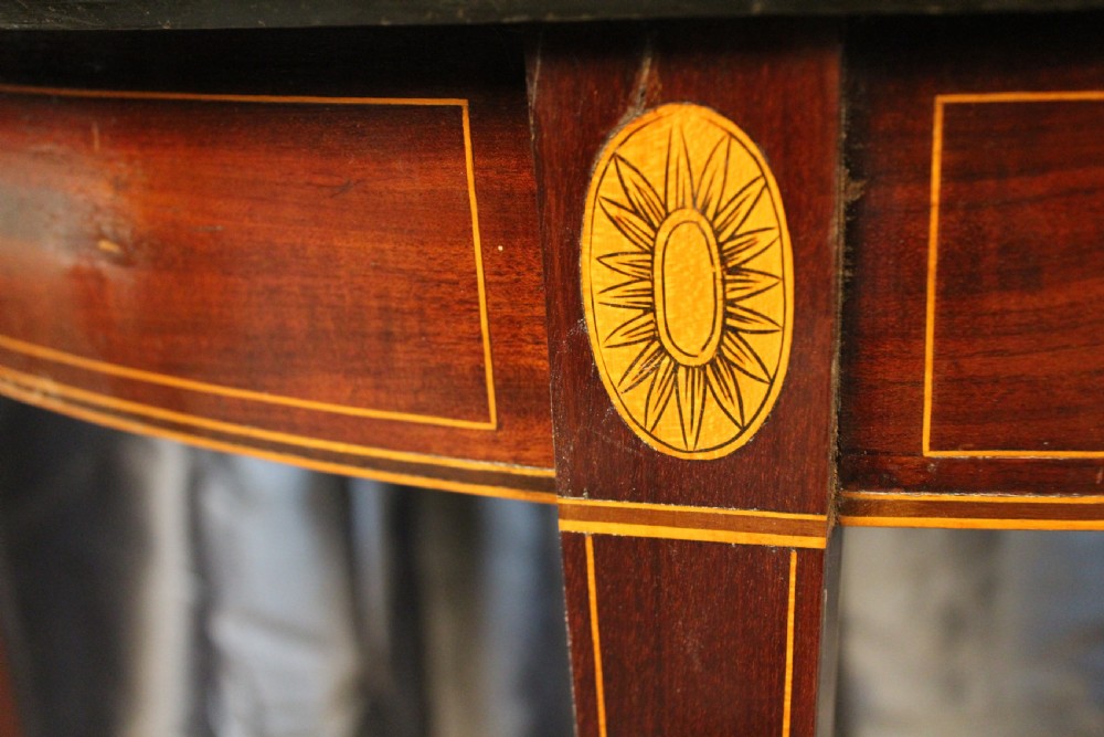 A semi-circular antique mahogany demilune card table featuring satinwood stringing inlays and slender tapered legs. View III