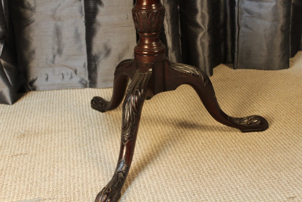 A mahogany tilt-top occasional table featuring a scalloped piecrust rim, turned column, and carved tripod legs. View VI