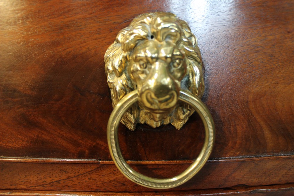 A mahogany bowfront sideboard featuring lion mask brass ring handles, boxwood stringing inlay, square tapered legs with spade feet, and an upper brass rail gallery. View III
