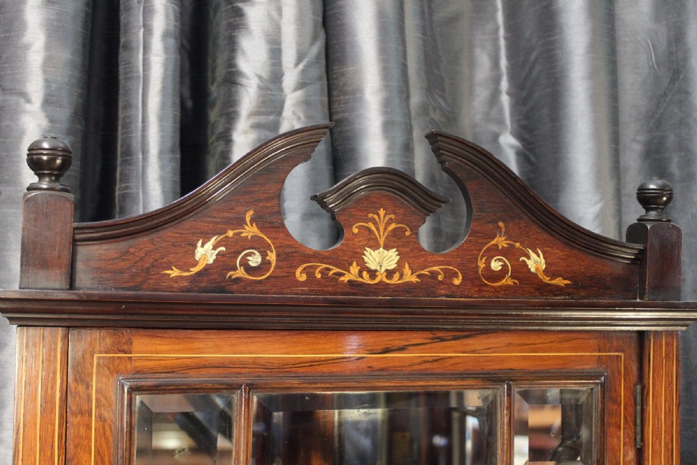 An antique dark wood corner display cabinet featuring delicate marquetry inlays, a glazed upper door, mirrored back sections, and open corner shelving. View IV