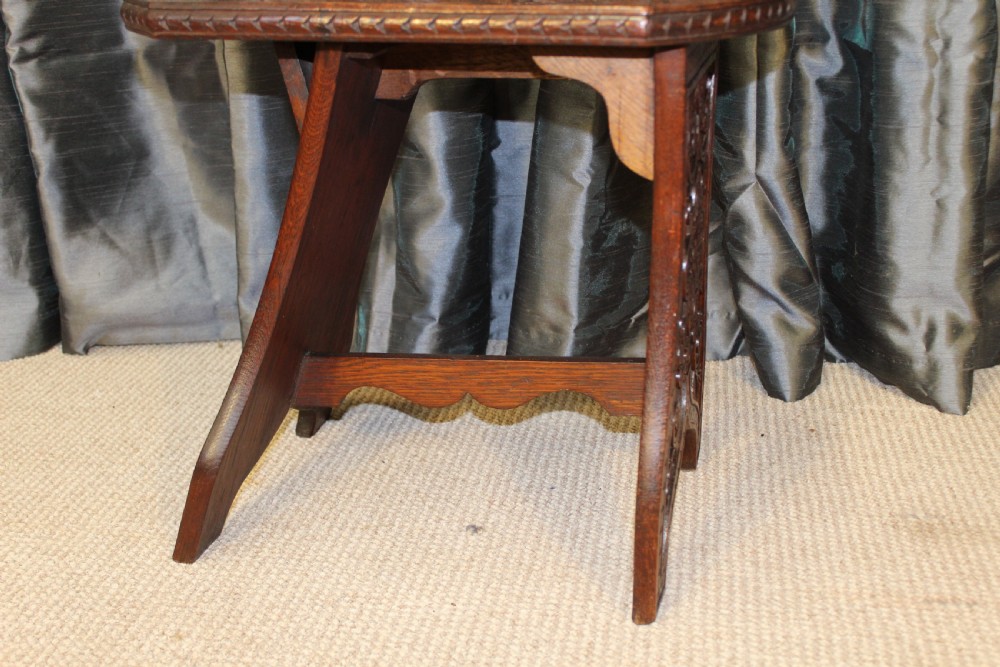A pair of dark carved oak hall chairs featuring tall shaped backrests with heraldic crest motifs and decorative carved slab bases. View V