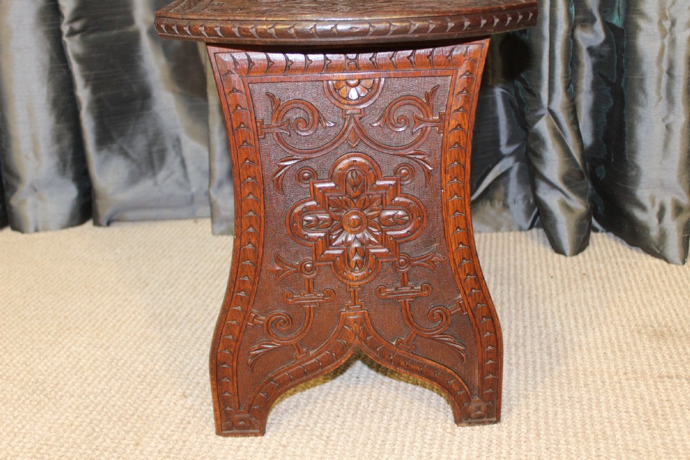 A pair of dark carved oak hall chairs featuring tall shaped backrests with heraldic crest motifs and decorative carved slab bases. View VI