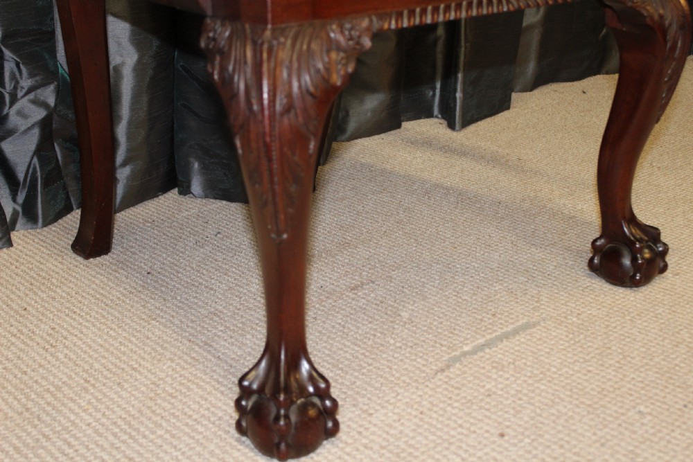 Set of eight mahogany Chippendale style dining chairs featuring carved pierced back splats, tan leather seats, and cabriole legs with ball and claw feet. View V