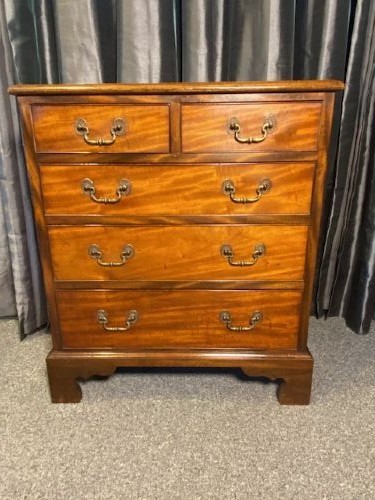 A mahogany chest of drawers featuring two short drawers above three long graduated drawers, fitted with brass swan-neck handles and raised on bracket feet.