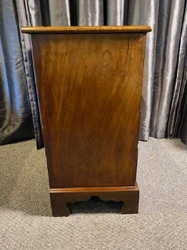 A mahogany chest of drawers featuring two short drawers above three long graduated drawers, fitted with brass swan-neck handles and raised on bracket feet. View V