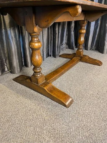 A solid oak refectory dining table featuring a broad rectangular top, twin turned pillar supports, and a floor-level stretcher base. View IV
