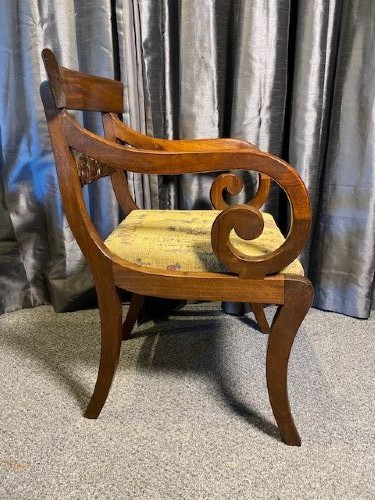 An antique mahogany carver chair featuring scrolled armrests, a foliate carved back rail, and patterned fabric upholstery. View II