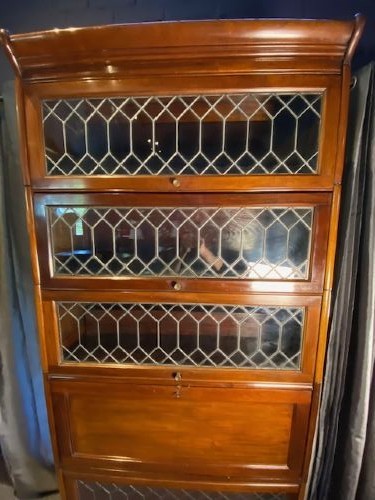 A tall dark mahogany sectional barrister bookcase with five leaded glass door compartments and a central wooden drop-front panel. View VIII