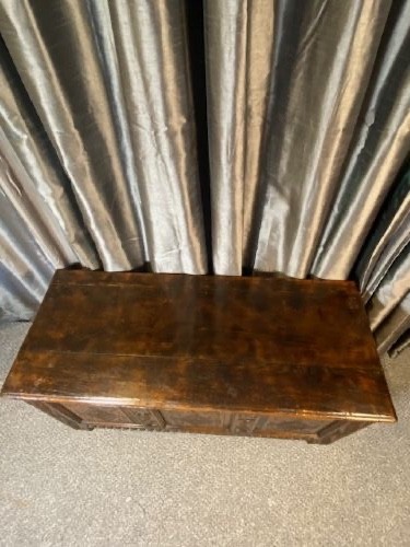 A dark carved oak coffer with three front panels featuring lozenge carvings and a carved upper rail. View III