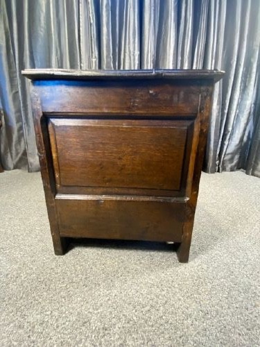 A dark carved oak coffer with three front panels featuring lozenge carvings and a carved upper rail. View VI