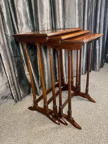 A set of three graduated mahogany nesting tables featuring light wood inlay borders on the rectangular tops and slender turned legs. View II