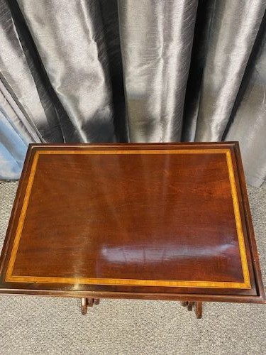 A set of three graduated mahogany nesting tables featuring light wood inlay borders on the rectangular tops and slender turned legs. View III