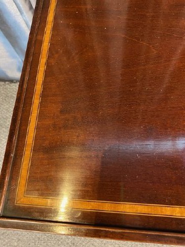 A set of three graduated mahogany nesting tables featuring light wood inlay borders on the rectangular tops and slender turned legs. View IV