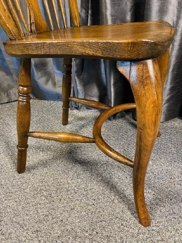 A set of six warm brown wooden Windsor dining chairs featuring hoop backs, pierced wheelback splats, shaped solid seats, and curved legs. View II