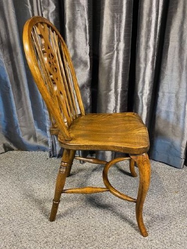 A set of six warm brown wooden Windsor dining chairs featuring hoop backs, pierced wheelback splats, shaped solid seats, and curved legs. View III