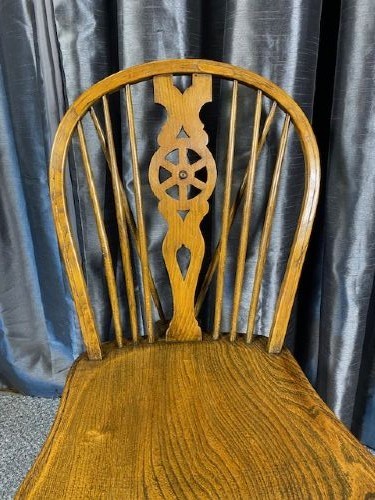 A set of six warm brown wooden Windsor dining chairs featuring hoop backs, pierced wheelback splats, shaped solid seats, and curved legs. View IV