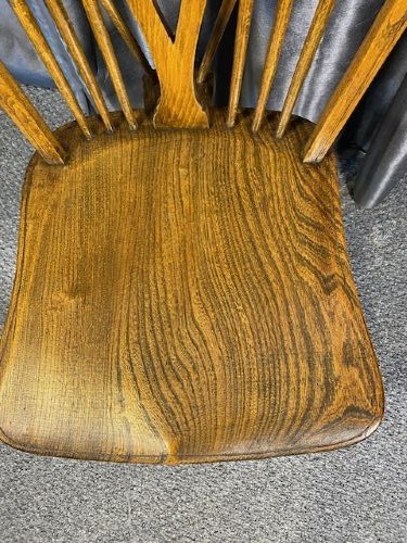 A set of six warm brown wooden Windsor dining chairs featuring hoop backs, pierced wheelback splats, shaped solid seats, and curved legs. View V