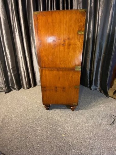 A nineteenth-century mahogany military campaign chest of drawers featuring flush brass handles, protective corner mounts, and turned feet. View IV