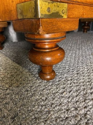 A nineteenth-century mahogany military campaign chest of drawers featuring flush brass handles, protective corner mounts, and turned feet. View V