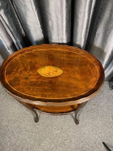An oval two-tier mahogany occasional table featuring scalloped rims, central floral marquetry inlays, and slender cabriole legs with claw feet. View II