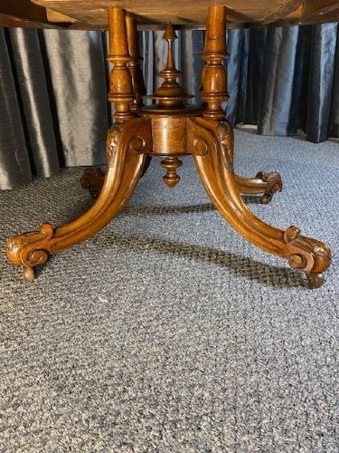 An oval burr walnut coffee table featuring detailed floral marquetry inlays on the tabletop and carved splayed legs. View III